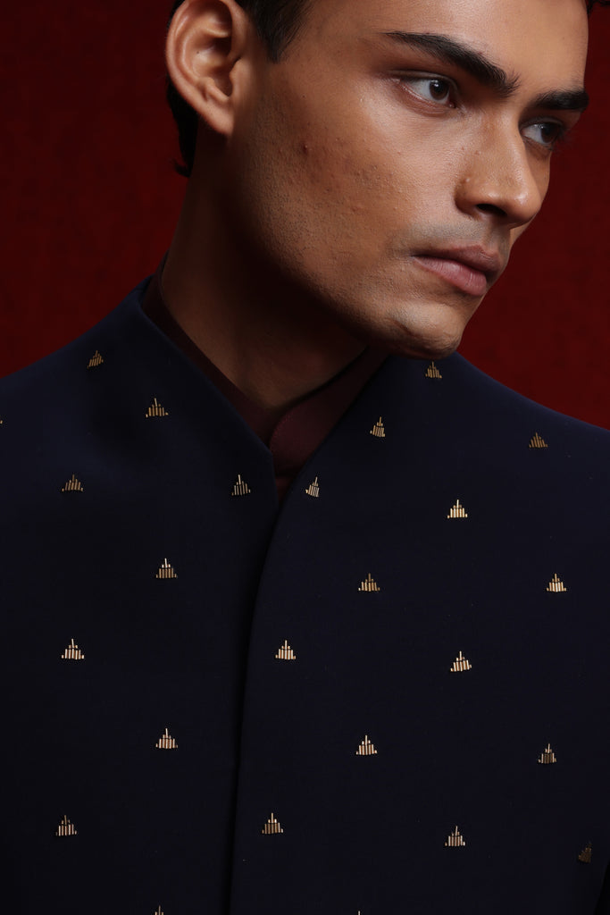 NAVY BLUE ASYM INDOWESTERN WITH ALL OVER MOTIF PAIRED WITH BURGUNDY BROAD STAND KURTA AND NAVY BLUE FITTED